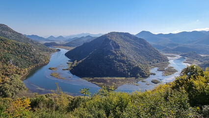 Scenic view from Pavlova Strana on horseshoe bend of river Crnojevica winding around Dinaric Alps mountains in Lake Skadar National Park, Bar, Montenegro, Balkans, Europe. Natural hilly landscape