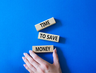 Time to save money symbol. Wooden blocks with words Time to save money. Businessman hand. Beautiful blue background. Business and Time to save money concept. Copy space.