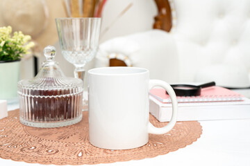 A white blank coffee mug standing out on a mat with some decorations placed around it