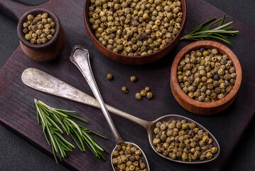 Spice, allspice green in a wooden bowl on a black concrete background