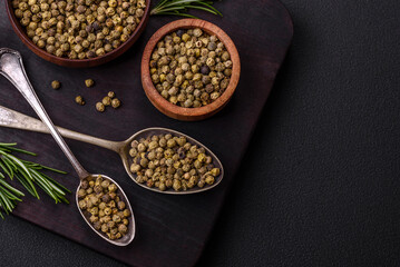 Spice, allspice green in a wooden bowl on a black concrete background