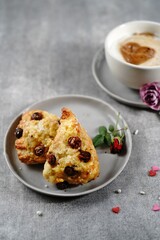 Valentines day breakfast  setting  - scones cappuccino heart and roses  on a tray, selective focus