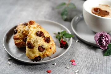Valentines day breakfast  setting  - scones cappuccino heart and roses  on a tray, selective focus