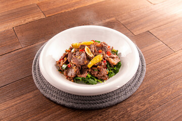 Stir-fried Yellow Beef with Coriander served dish isolated on wooden table top view of Hong Kong food