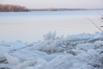 blocks of ice near the river bank. Ice drift of ice floes on rivers and lakes under the influence of current or wind. Accumulation of melt water between the bank and the edge of the ice on the river