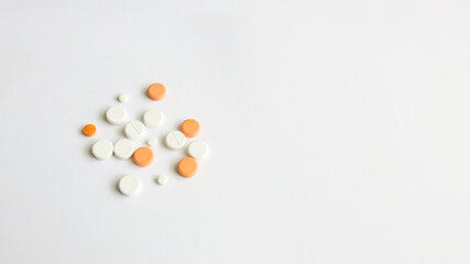 Assorted scattered pharmaceutical medicine pills and tablets in various colour and size isolated in white background, copy space for text or advertising
