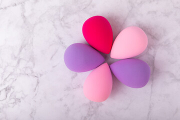 Obraz premium Beauty blender on light marble background. Cosmetics, makeup application tool. Beauty concept. Copy space. Place for text.