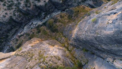 Aerial drone view of dry mountain river. Stone gorge. Green plants on the rocks. Beautiful landscape.