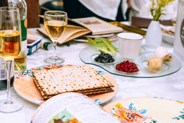 Passover table setting with a traditional Passover seder plate with symbolic meal, matzah and...
