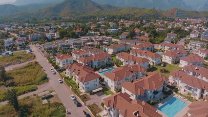Fototapeta na wymiar Aerial panorama of small resort town. Hotels, houses and roads. Green hills around. Mountain landscape. Photography