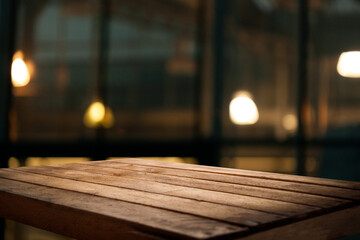 Empty dark wooden table in front of restaurant abstract blurred bokeh background. Can be used to...