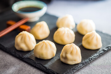 Xiaolongbao, traditional steamed dumplings. Xiao Long Bao buns on cutting board.