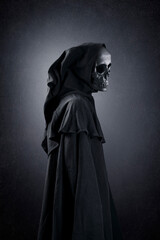 Fototapeta na wymiar Grim reaper over dark misty background
