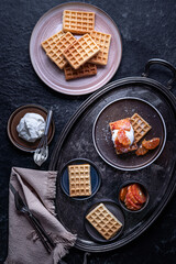 Belgian waffles with oranges and wippet cream. Served on a silver antique tray. Top view. Photo in rustic style.