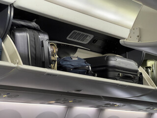 Fototapeta na wymiar Airplane overhead luggage compartment suitcases