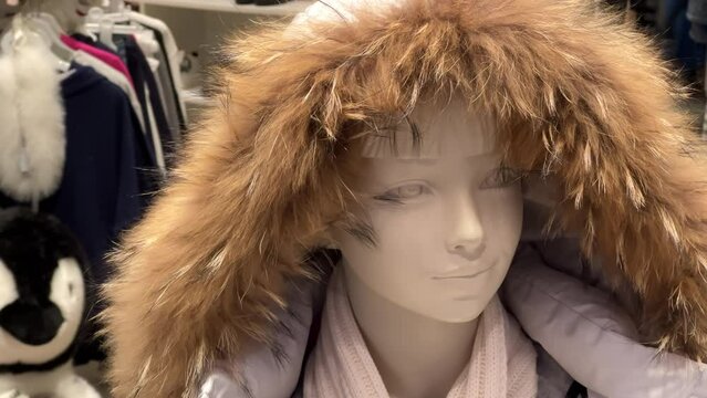 Mannequin in a snorkel parka stands in the window of a clothing store