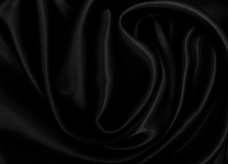 Smooth elegant black silk or satin luxury cloth texture as abstract background. Luxurious background design