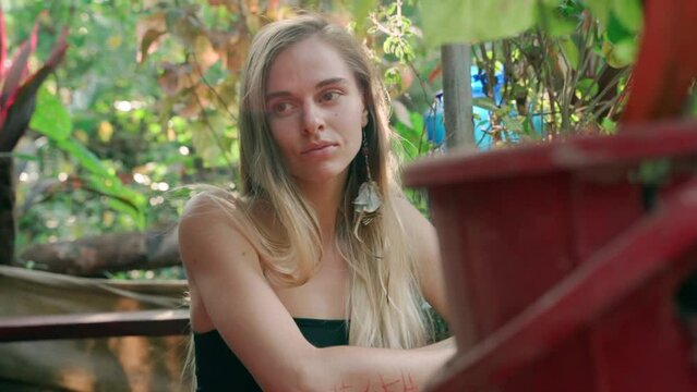 The young woman looks enigmatically into the camera, modestly turning her head