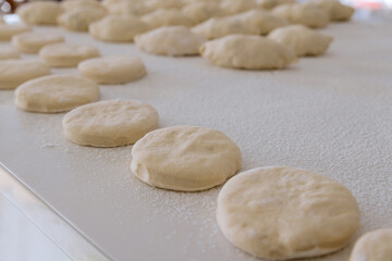 Fototapeta na wymiar White countertop is used for preparing baking of buns with stuffing and donuts from yeast dough