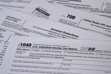 In 2023, a a tax year 2022 IRS 1040 tax form is shown, along with Itemized Deductions (Schedule A) and Gift (form 709) worksheets. The Internal Revenue Service tax filing deadline in 2023 is April 18.