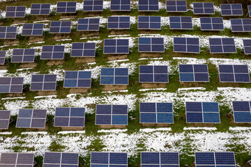 drone view of photovoltaic plant in winter, panels for solar green energy generation, in mountain...