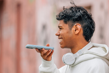 young latin man with mobile phone sending voice message