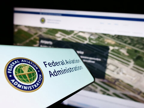 Stuttgart, Germany - 01-24-2023: Cellphone with seal of US Federal Aviation Administration (FAA) on screen in front of website. Focus on center-left of phone display.
