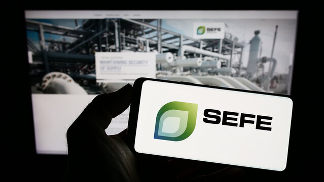 Stuttgart, Germany - 01-24-2023: Person holding mobile phone with logo of company SEFE Securing Energy for Europe GmbH on screen in front of web page. Focus on phone display.