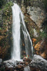 A girl in a green swimsuit near a waterfall in Albania