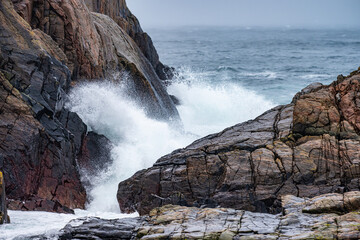 Waves crashing against cliffs during a winter storm.
