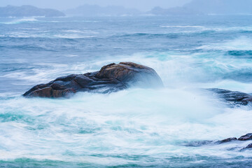 Fototapeta premium Waves crashing against cliffs during a winter storm.