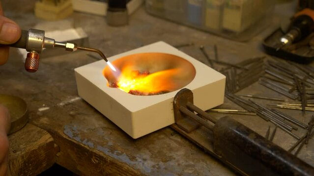 Goldsmith melting a batch of Gold Jewelry into a nugget