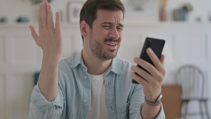 Young Man Reacting to Loss on Smartphone