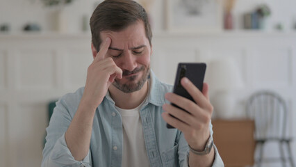 Young Man Reacting to Loss on Smartphone