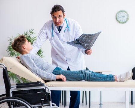 Young Male Doctor Pediatrist And Boy In Wheel-chair