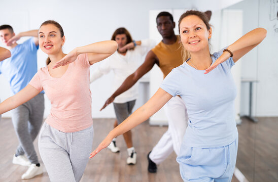Group of energetic different people learning dance at dance class © JackF