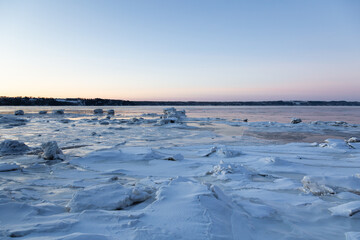 Blue hour view of the partly frozen St. Lawrence river and the south shore seen during a cold winter sunrise, Quebec City, Quebec, Canada