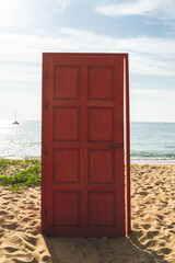 A closed red wooden door at a beach.