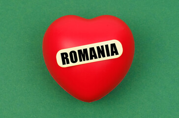 On a green surface lies a red heart with the inscription - Romania