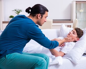 Obraz premium Young father caring for sick son