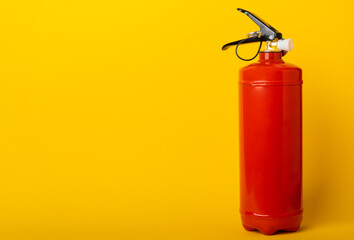 Fire extinguisher on yellow wall background. fire safety. Place for text. MOCAP