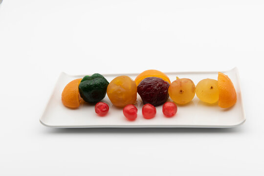 Plato con frutas confitadas, aislado en blanco