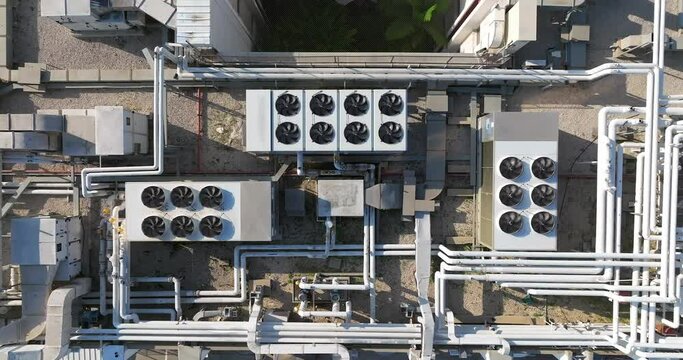 Industrial building rooftop with vents and pipes lined across, Top down view