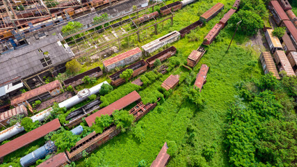 abandoned train station and wagon, with forest covering part of them. Aerial view on the city of Sorocaba, Brazil