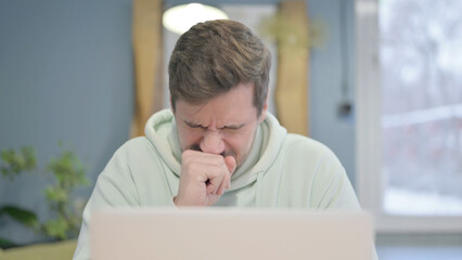 Close Up of Young Man Coughing while Working on Laptop