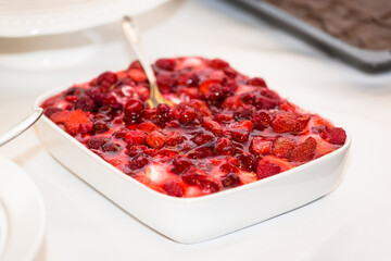 dessert in a bowl with sweet cream and berries as topping