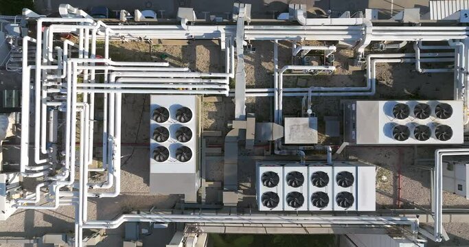 Industrial building rooftop with vents and pipes lined across, Top down view