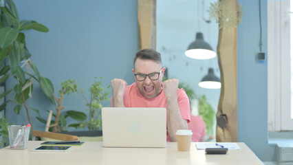 Creative Old Man Celebrating Success while using Laptop