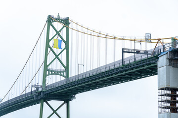Ukrainian flag hold on Angus L. Macdonald Bridge in Halifax, Nova Scotia, Canada