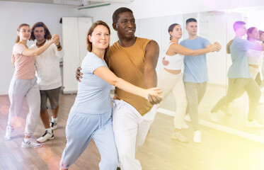 Fototapeta premium Couple male and female rehearsing pair dance in dance studio
